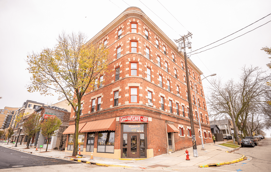 A red brick building with awnings on the ground floor.