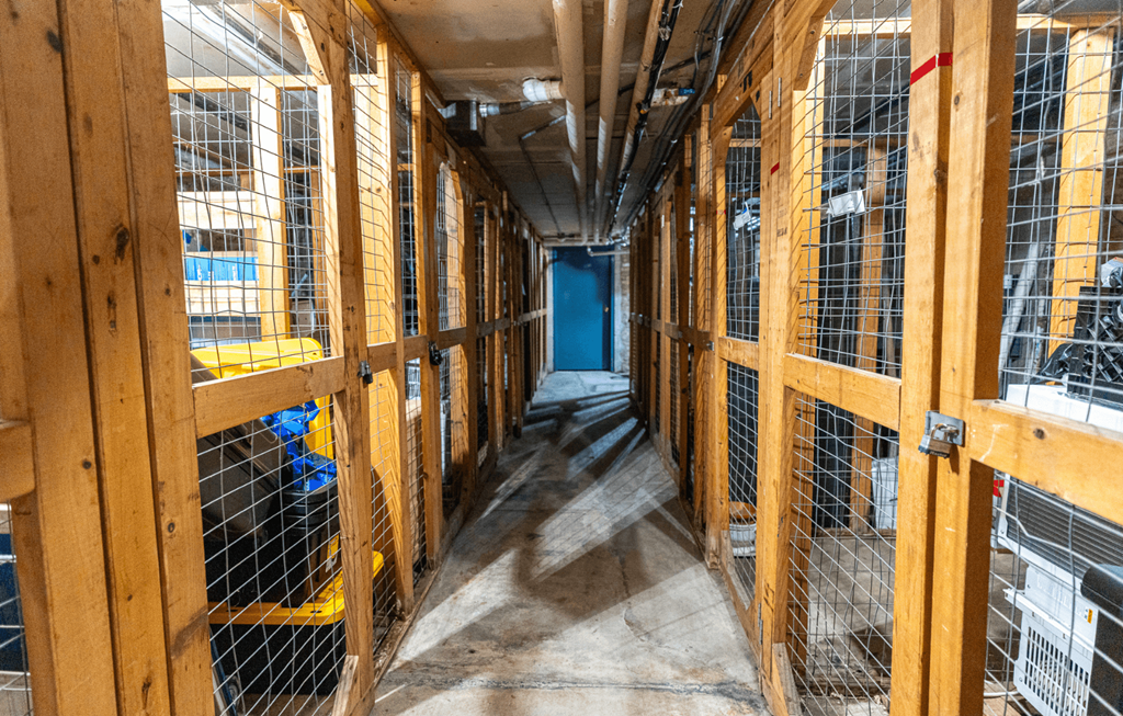 A long, narrow construction site with wooden framing and a blue door at the end.