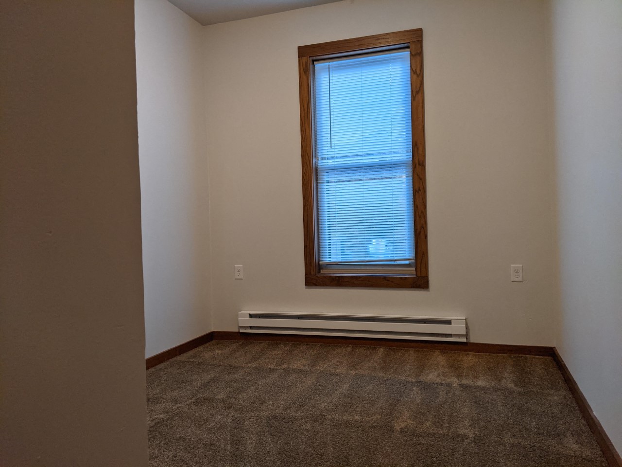 an empty room with a window and a carpet