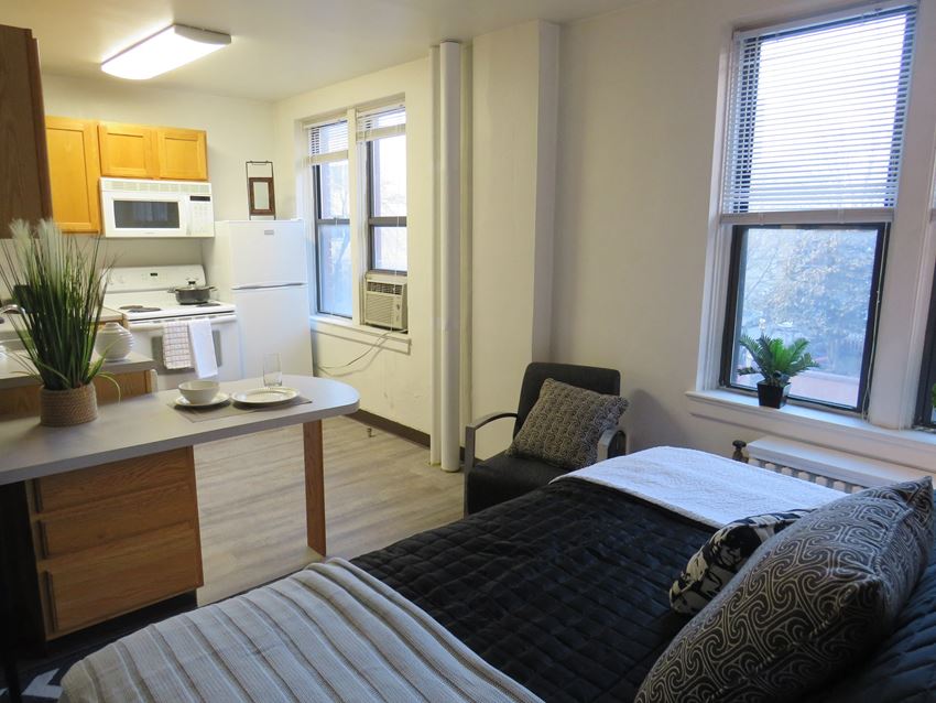 a bedroom with a bed and a kitchen with a sink