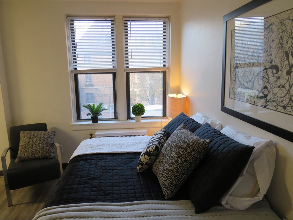 a bedroom with a bed and three windows