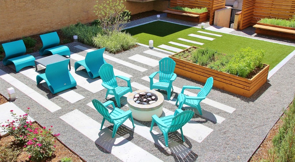 a patio with blue chairs and a fire pit