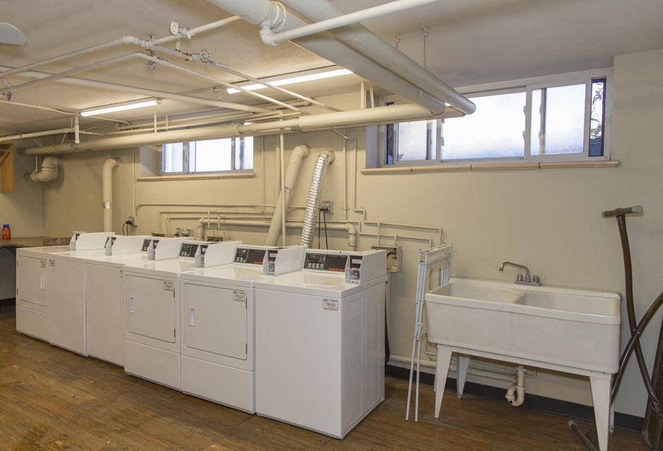 a row of washing machines and sinks in a room