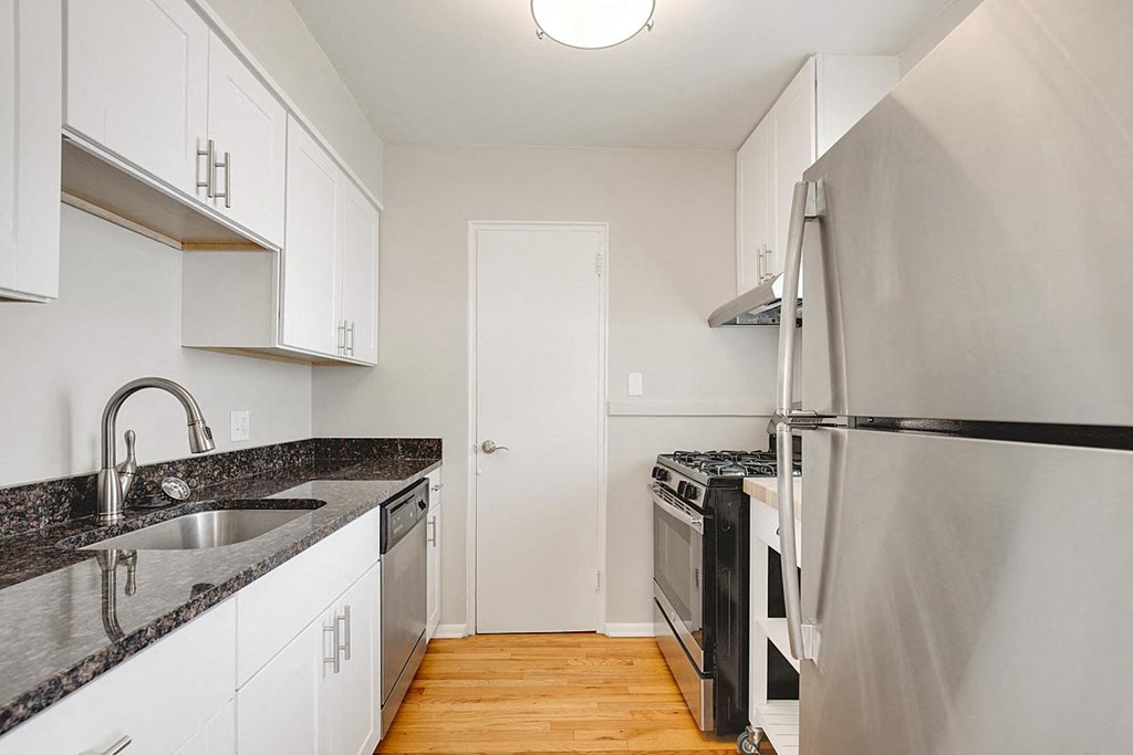 a kitchen with stainless steel appliances and white cabinets