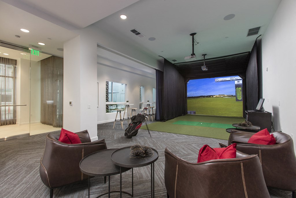 a clubhouse with a golf simulator and a large screen tv