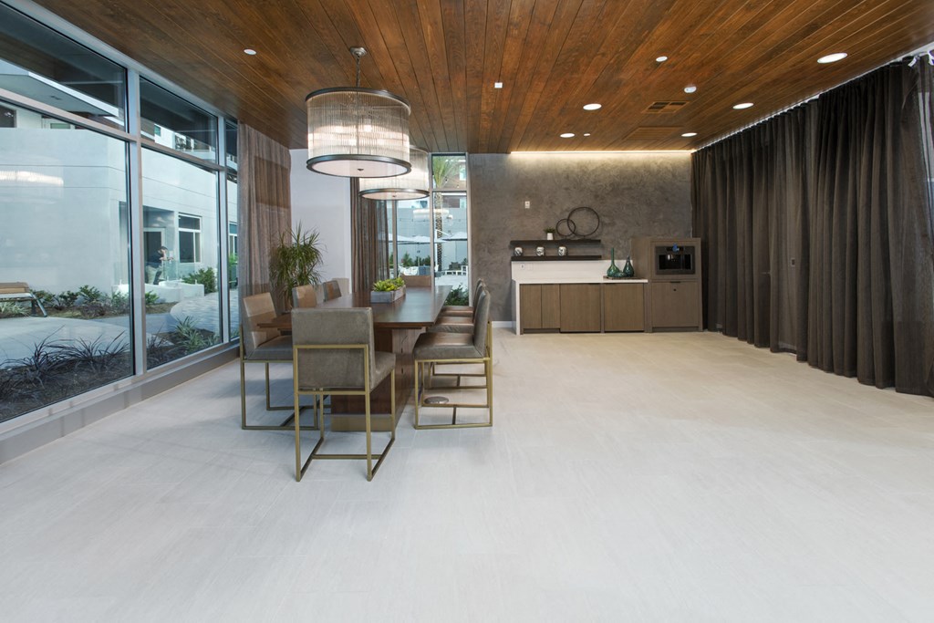 a dining area with a table and chairs in a room with large windows