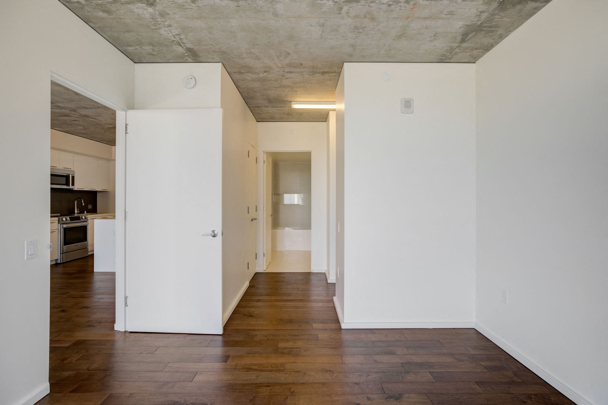 an empty living room with white walls and wood floors