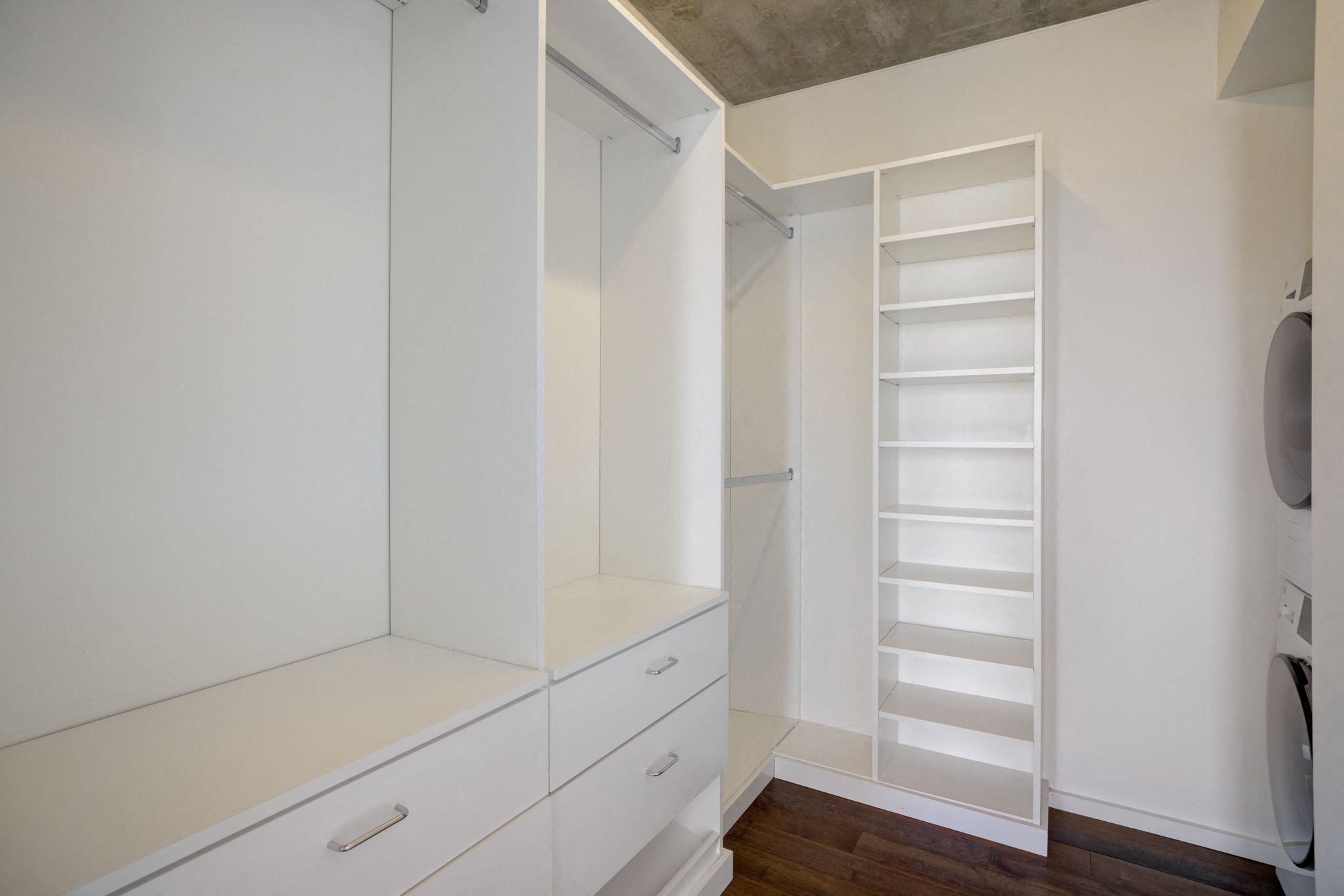 a large white closet with white drawers and