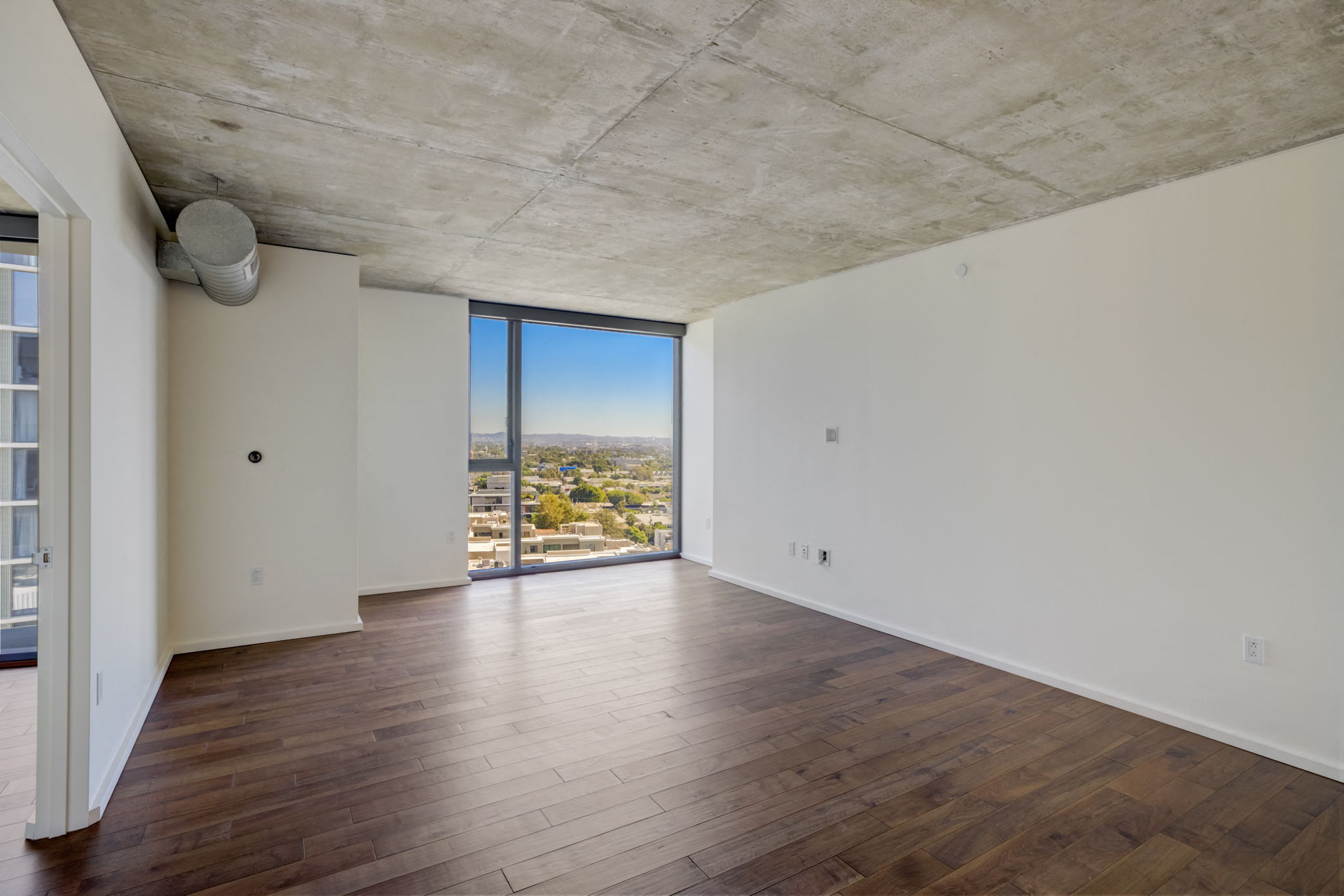 a living room with hardwood floors and a view of the city