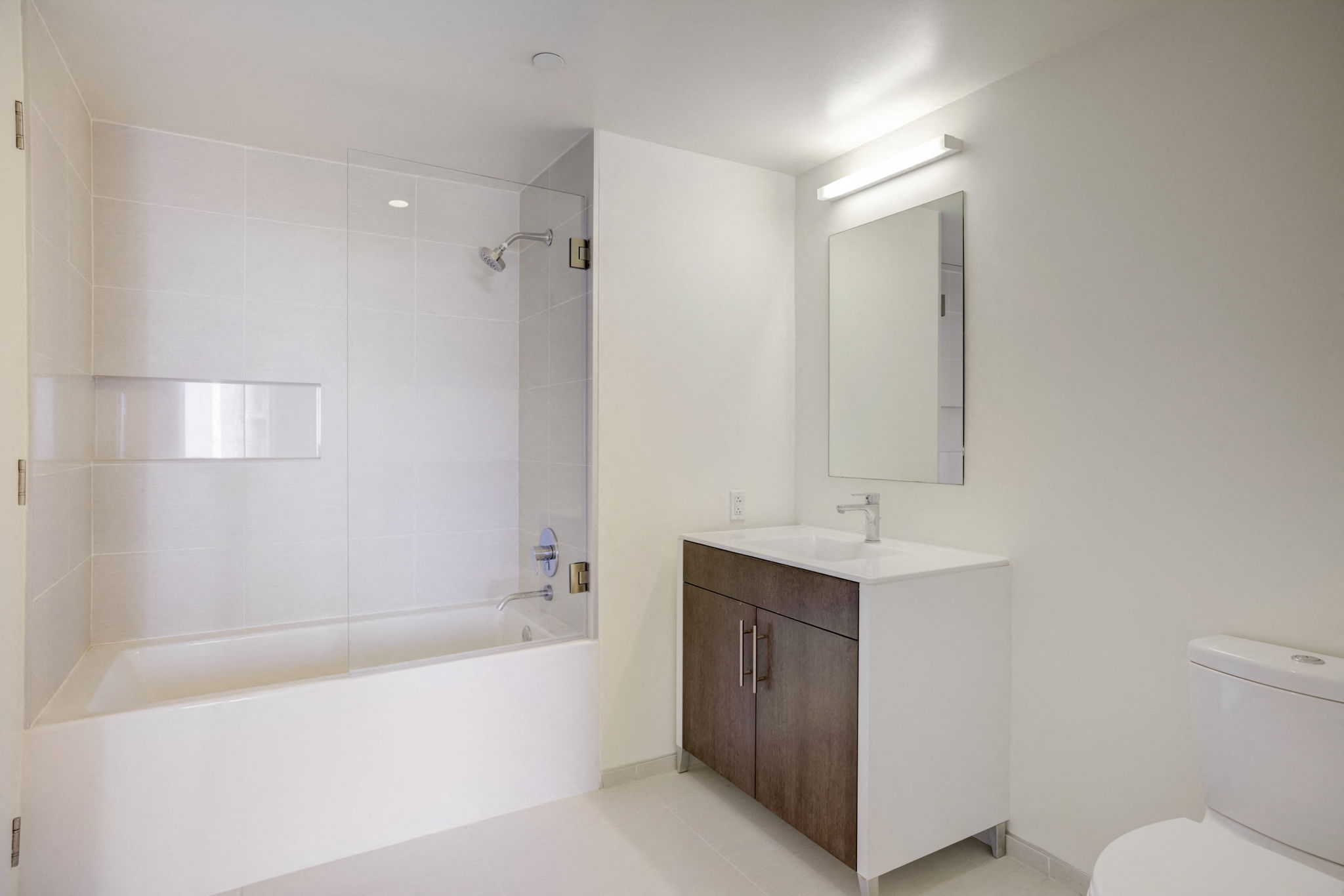 a white bathroom with a sink and a bath tub
