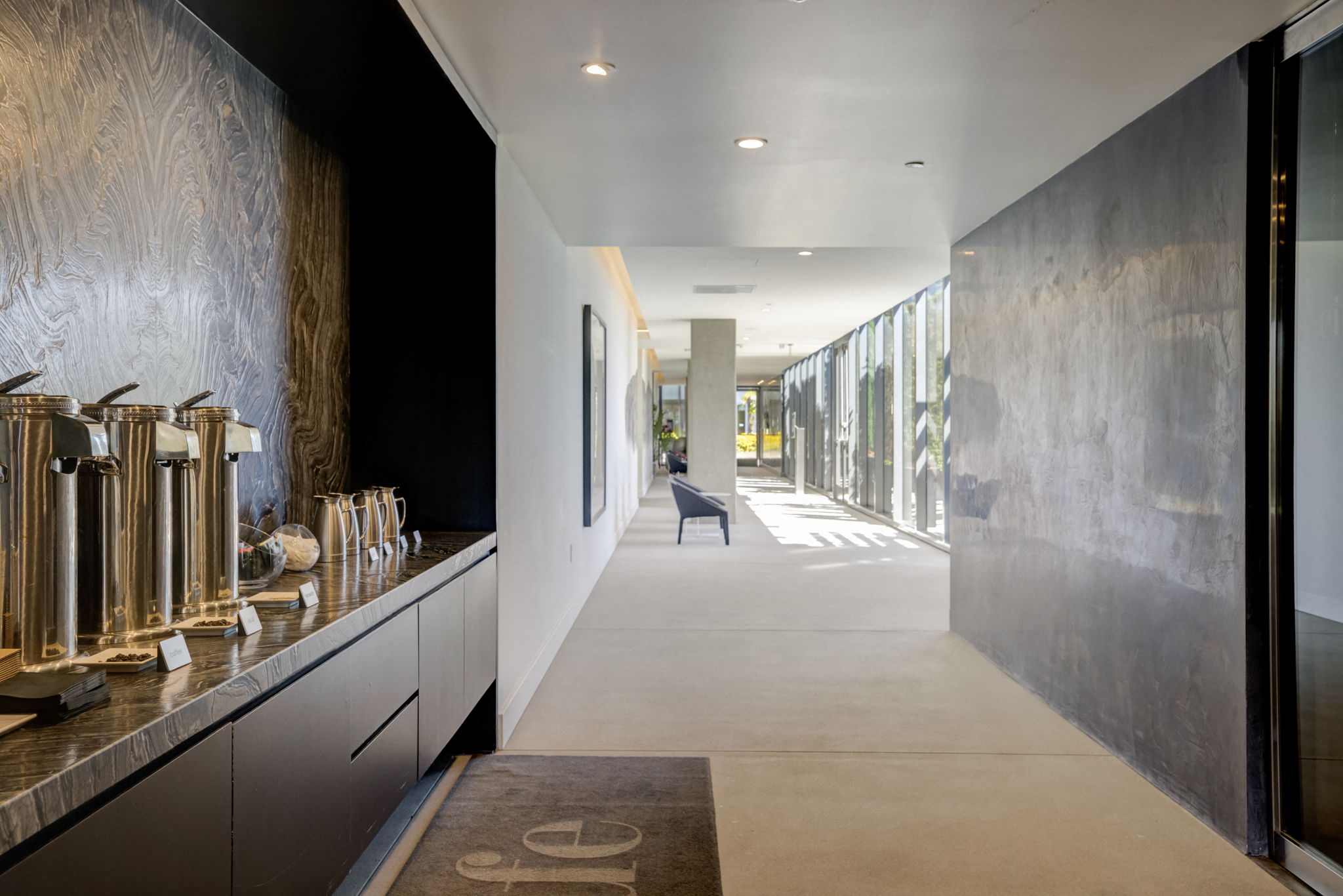 a long hallway with black walls and a counter with coffee grinders
