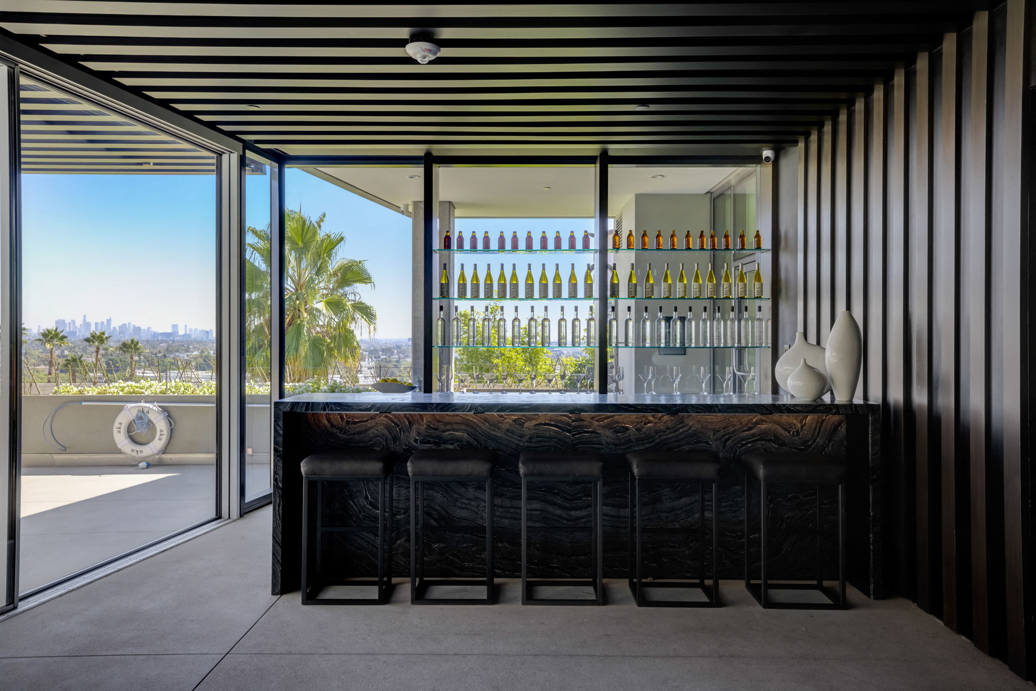 the bar in the living room has views of the ocean and palm trees