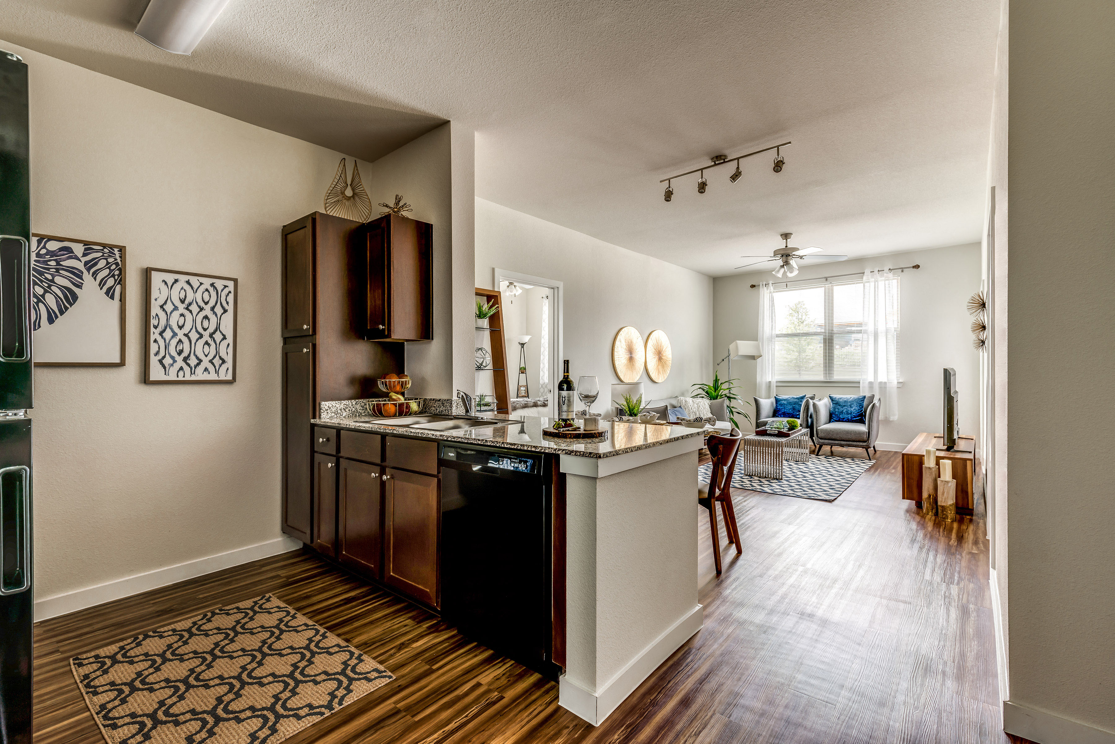 A kitchen with a black dishwasher and wooden cabinets.