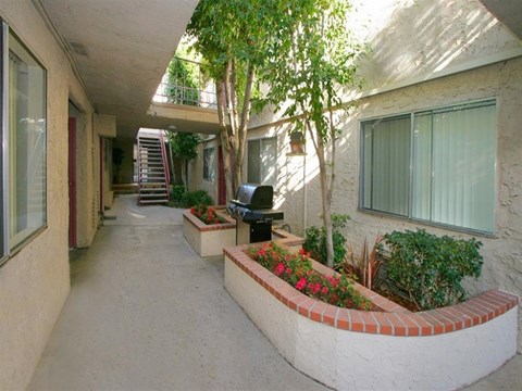 an empty hallway with a tv and plants in a building