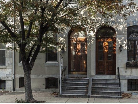 a building with steps and a tree in front of it
