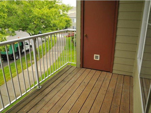 a porch with a red door and a metal railing