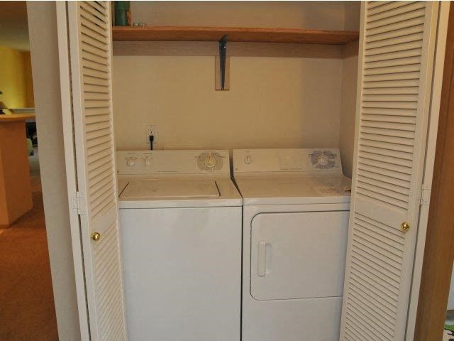 a small laundry room with two white machines