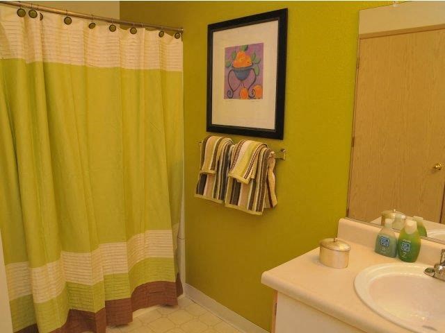 a bathroom with a yellow shower curtain and a sink