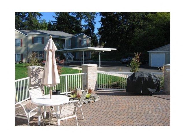 a patio with a table and chairs and an umbrella