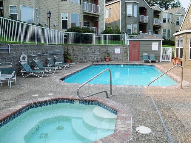 a swimming pool and a spa in front of an apartment building