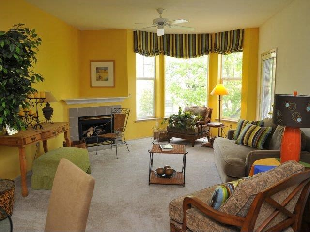 a living room with yellow walls and a white carpet