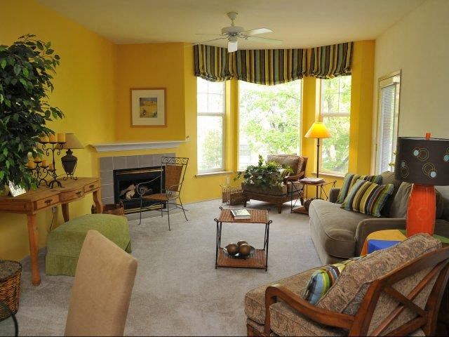 a living room with yellow walls and a white carpet