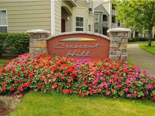 a sign with flowers in front of a building