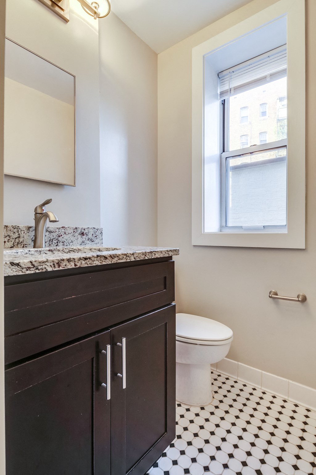 a bathroom with a toilet and a sink and a window
