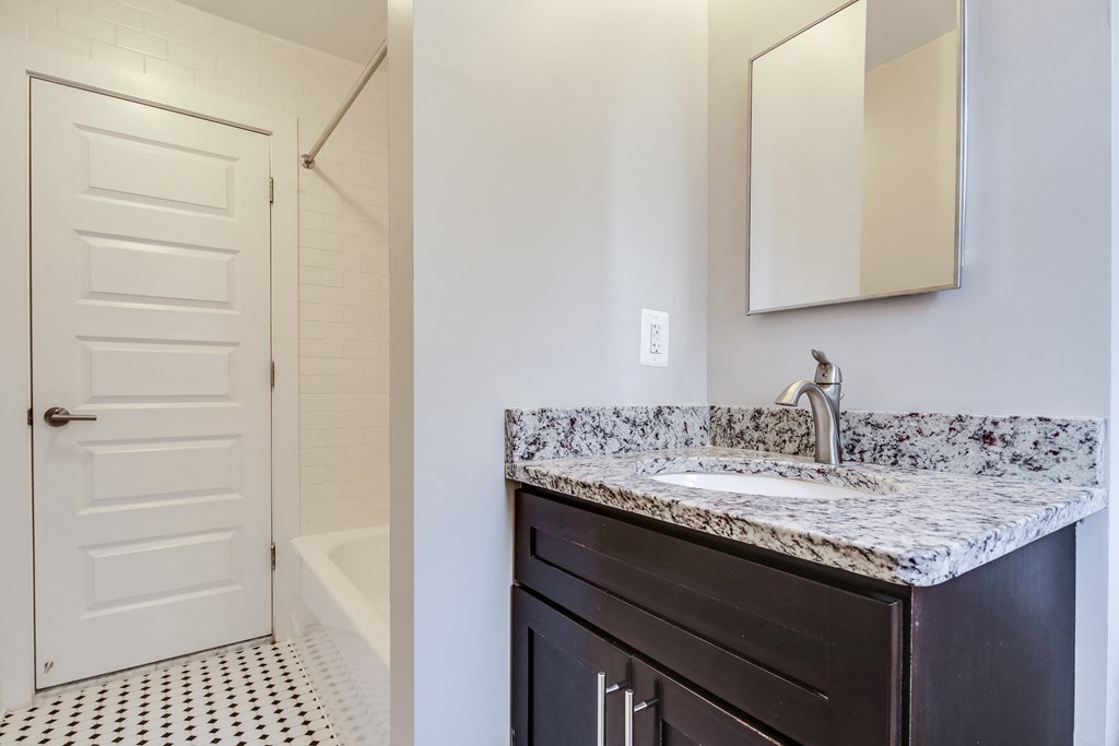 a bathroom with a sink and a shower and a mirror