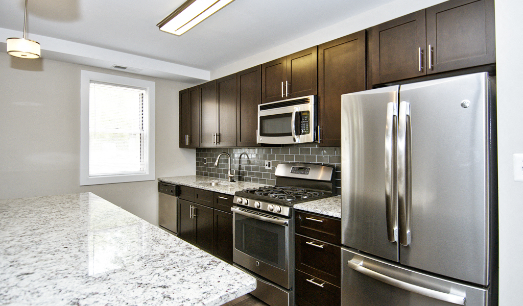 a kitchen with stainless steel appliances and marble counter tops