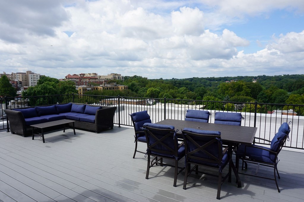 a deck with a table and chairs on top of a roof