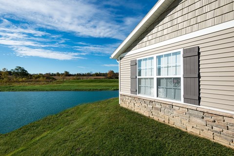 A house with a view of a lake and trees.