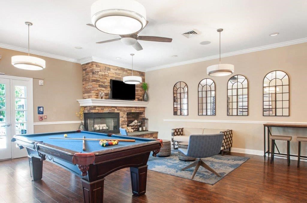 a living room with a pool table and a fireplace