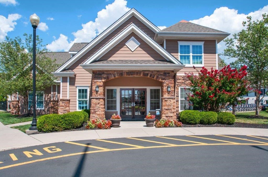 the front of a brick house with a sidewalk in front of it