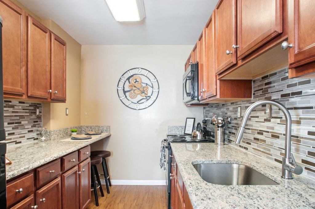 a kitchen with granite counter tops and wooden cabinets