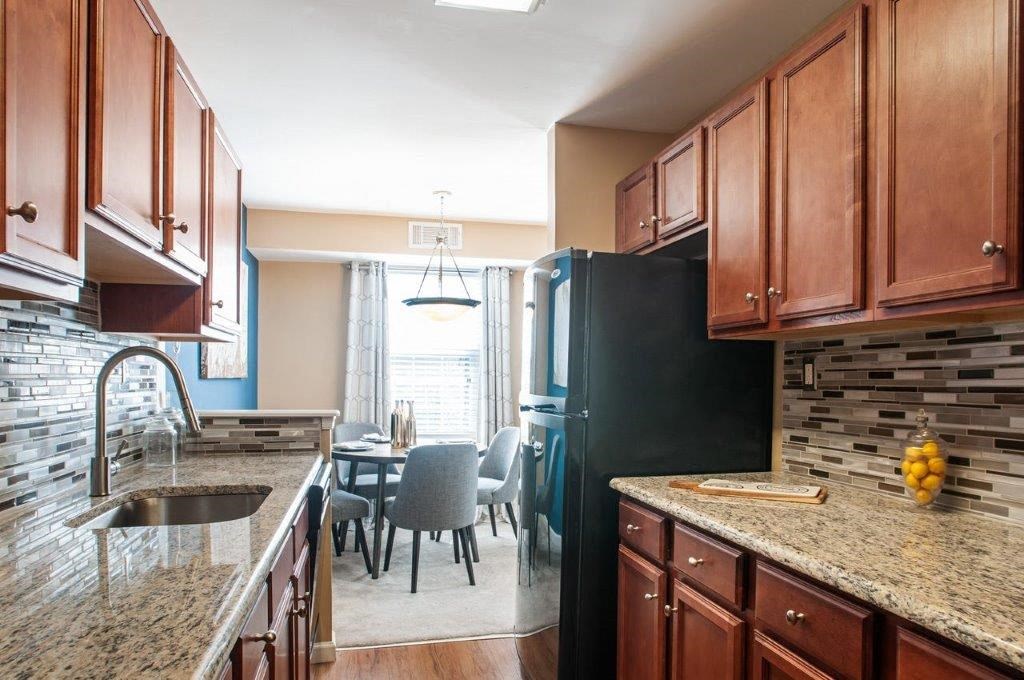 a kitchen with a sink and a black refrigerator