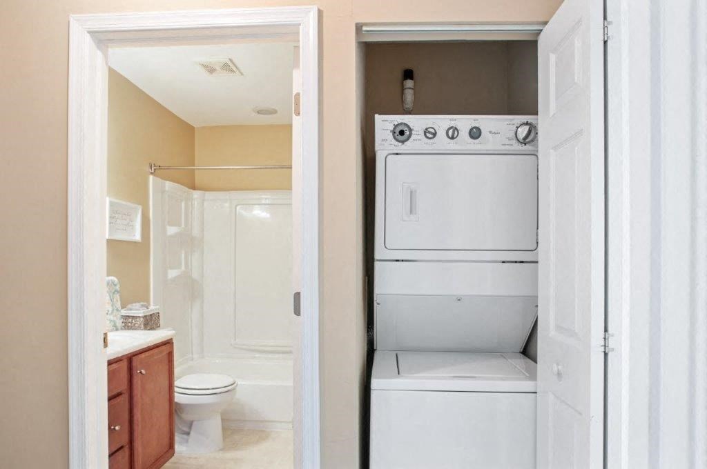 a bathroom with a washer and dryer and a toilet