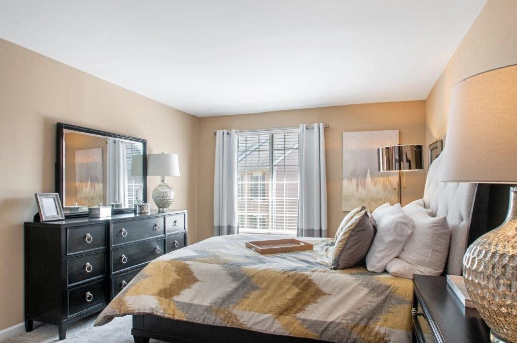 a bedroom with a bed and a dresser and a window