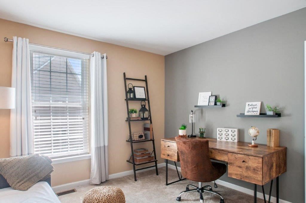 a bedroom with a desk and a window