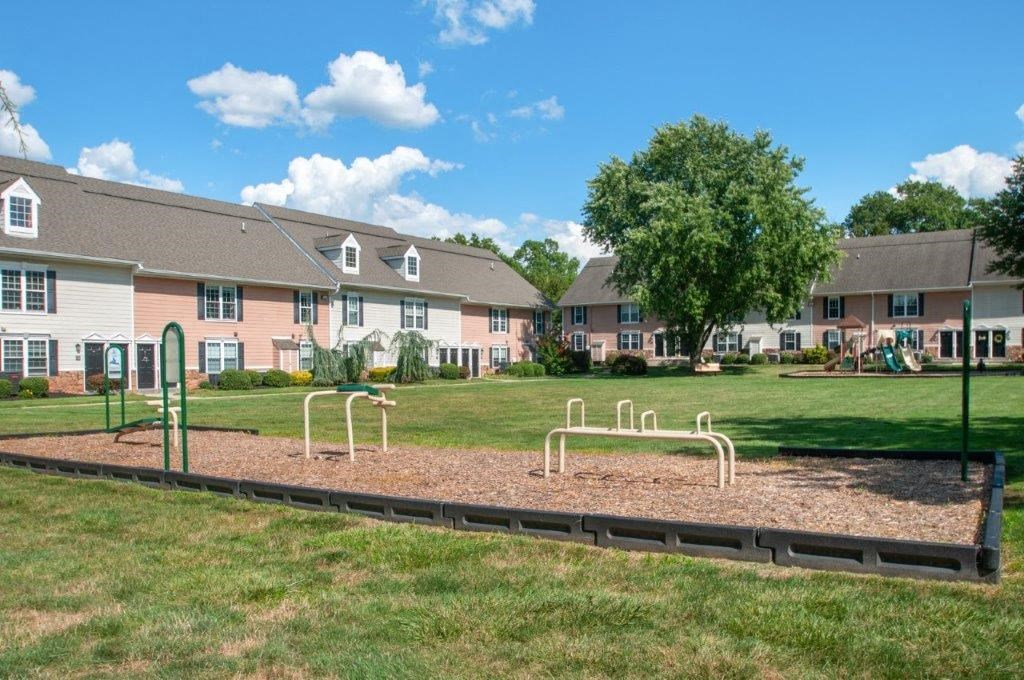 a playground in a park with houses in the background