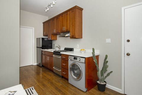 A kitchen with wooden cabinets and a washing machine.