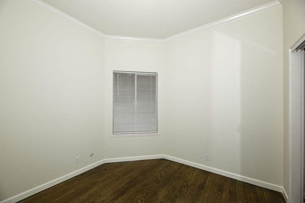 A room with a window and wooden floors.