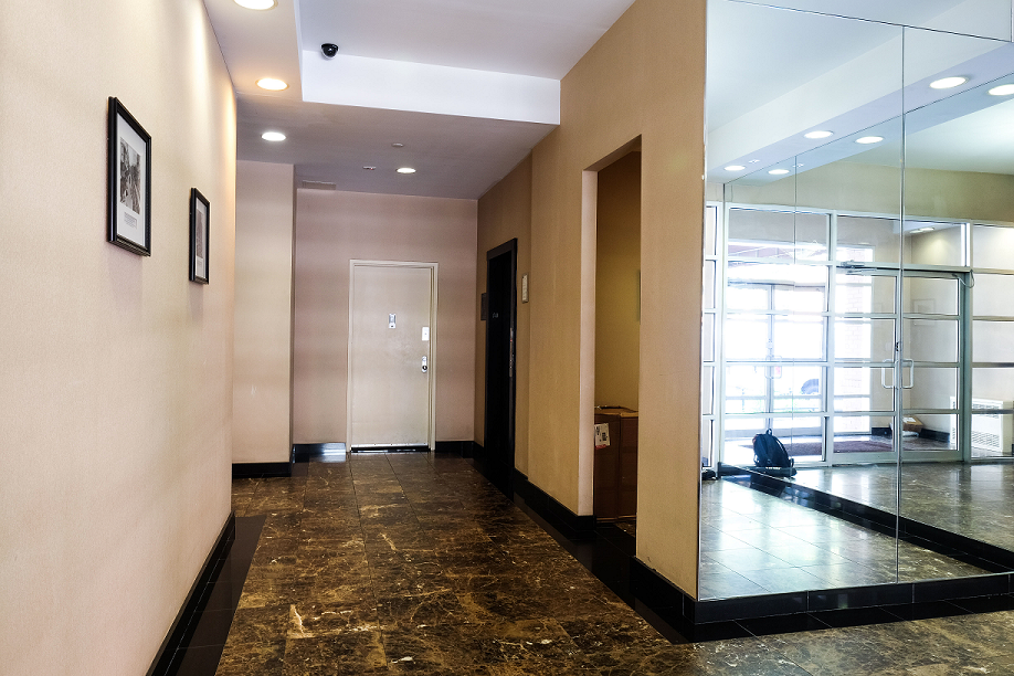 a hallway with glass doors and a marble floor