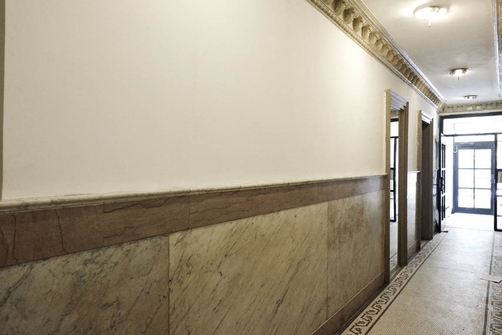 the lobby of the building has a long wall with wood trim