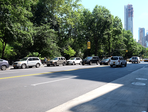 a busy city street with cars driving down it