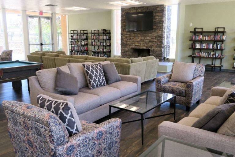 a living room with couches and chairs and a pool table