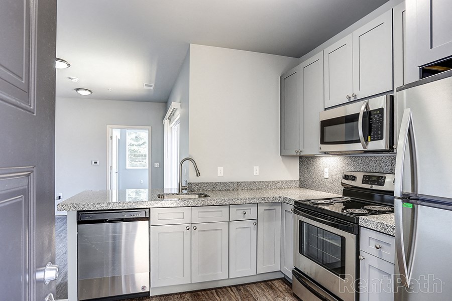 a kitchen with white cabinets and stainless steel appliances