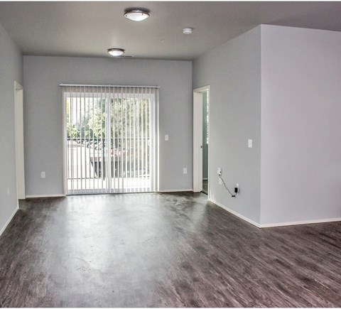 the living room of an empty apartment with a sliding glass door