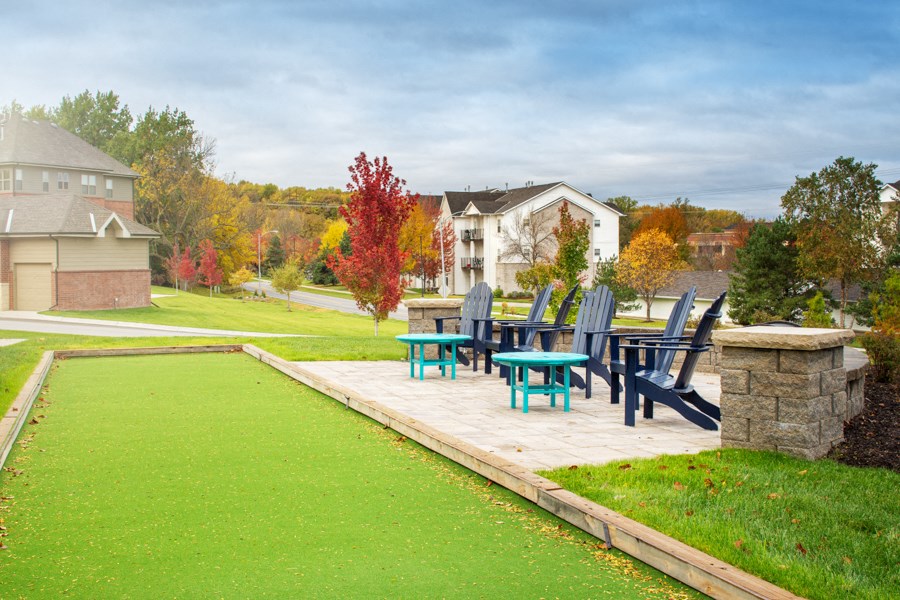 a patio with chairs and a table on a wooden deck