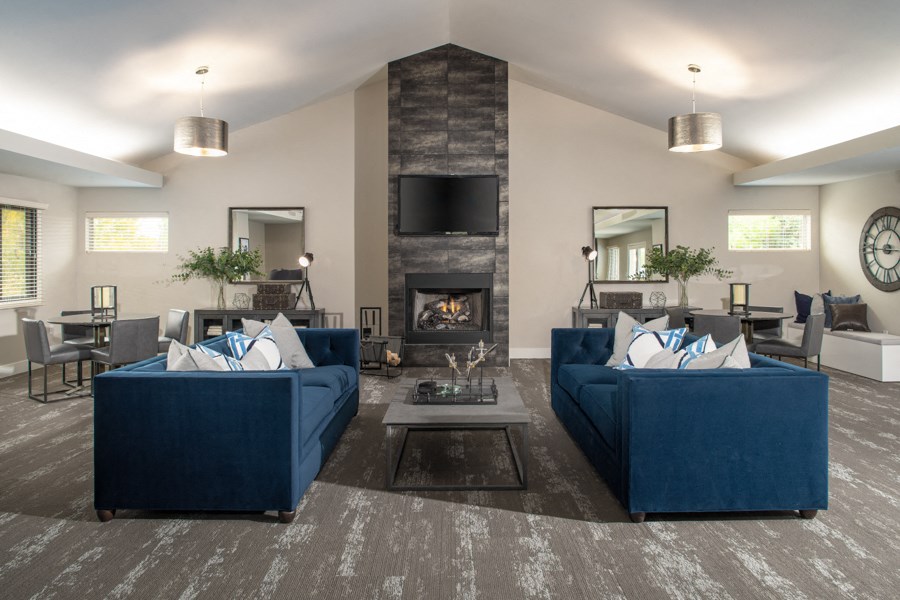 a living room with blue couches and a fireplace